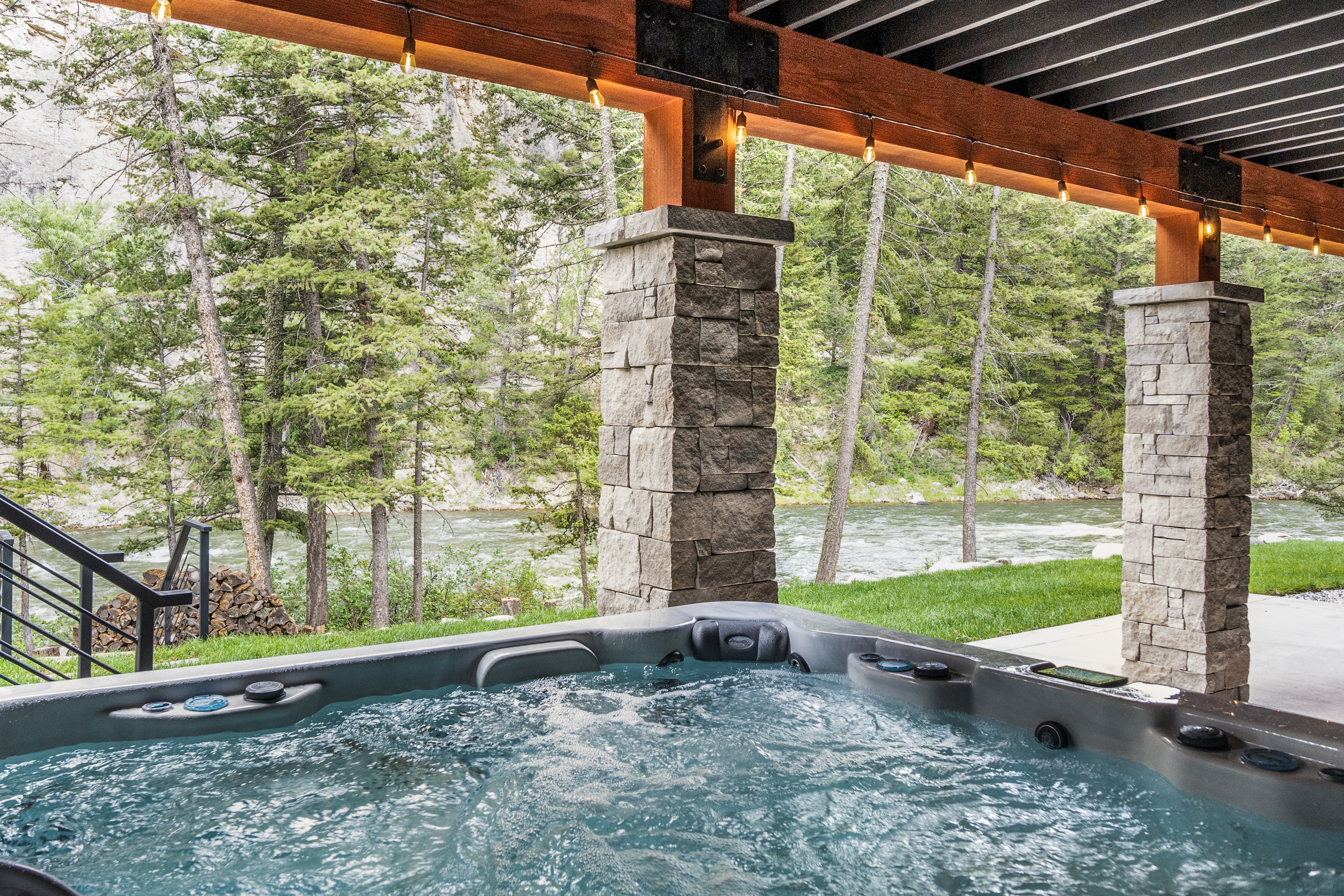Hot tub under covered deck with river view