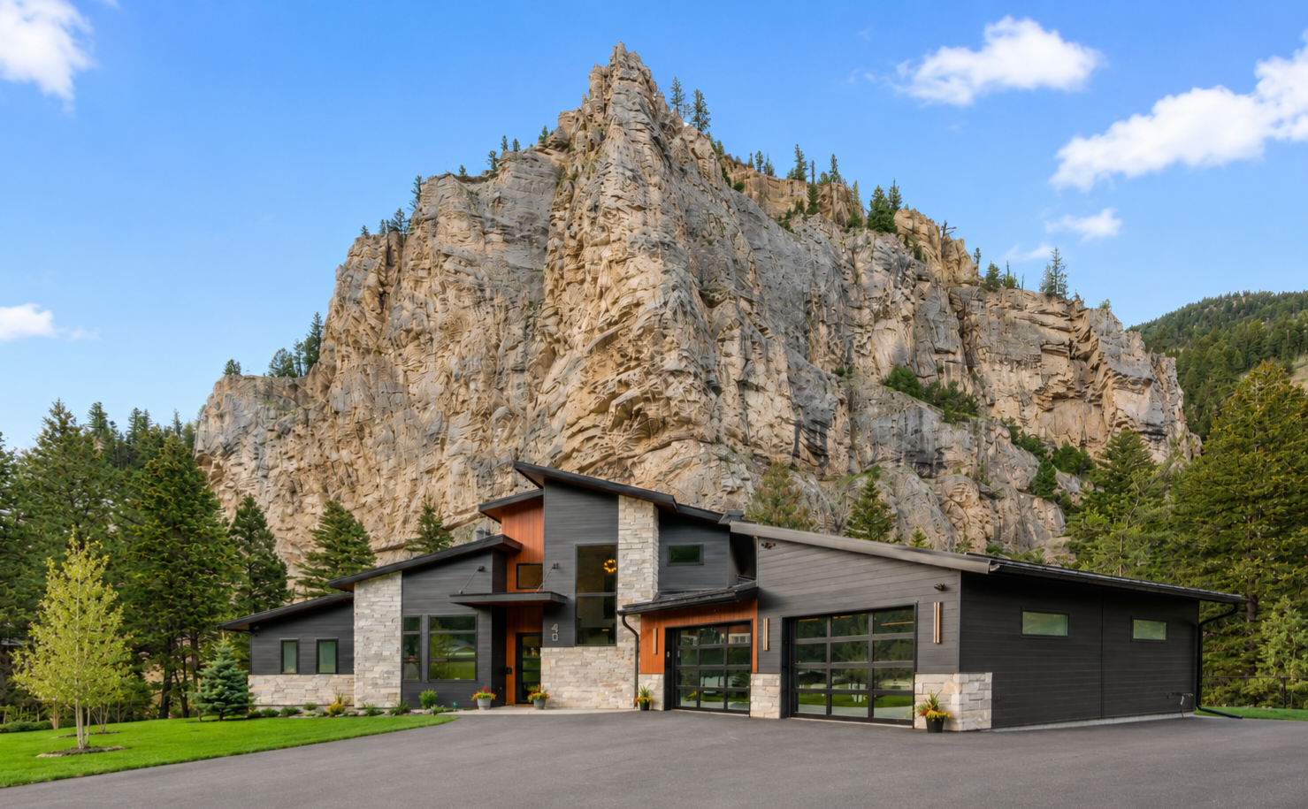 Front exterior with dramatic rock face backdrop